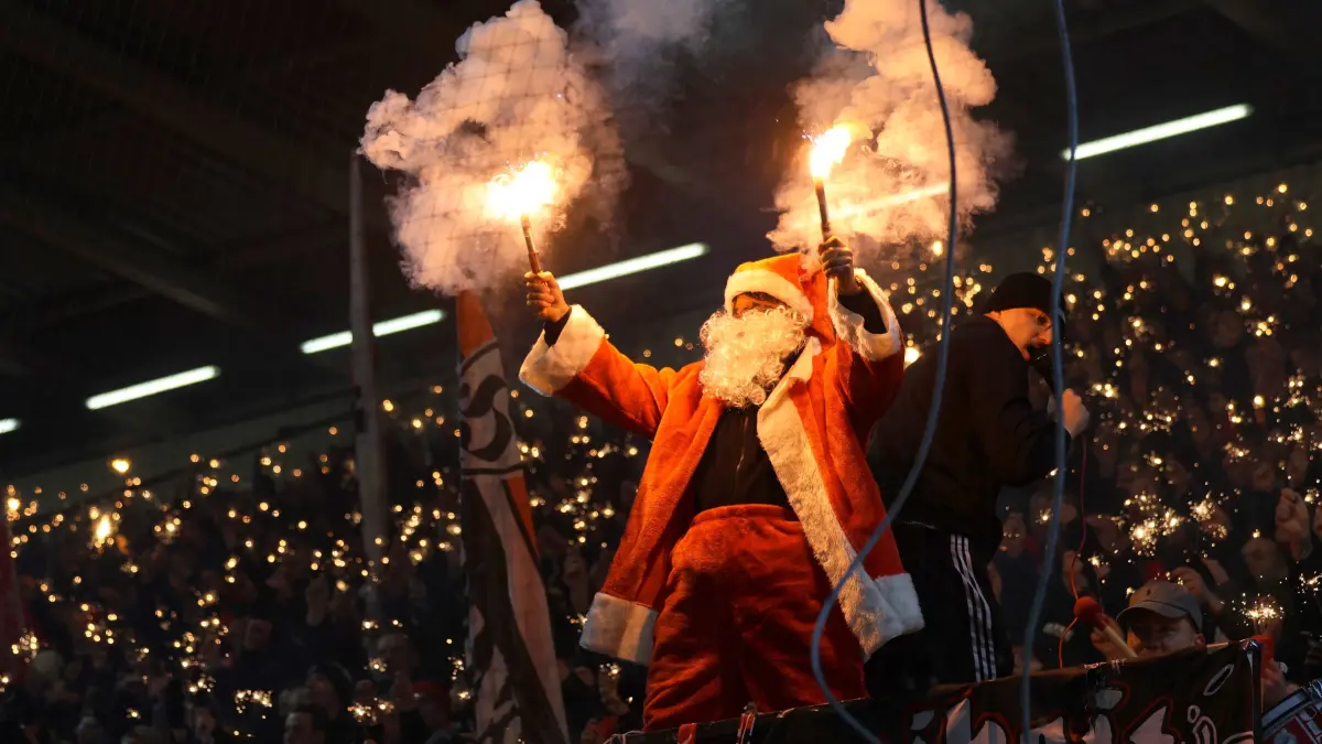 Fussball 3. Liga 2025/2026 FC Energie Cottbus - SSV Jahn Regensburg: Die Energiefans feiern das Jahresende 2025 im mit Weihnachtsmann und Lichtermehr.