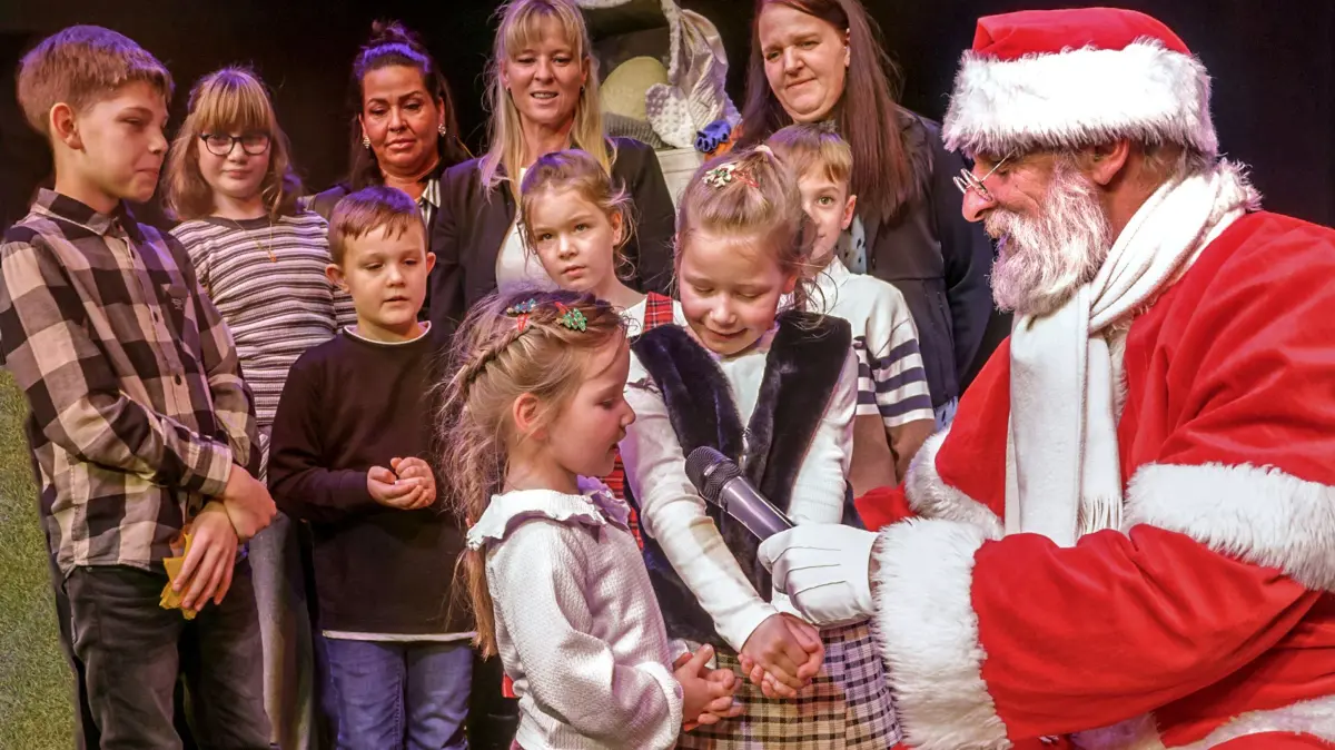 Frankfurt(Oder), 11.12.2026 - Theater des Lachens - 80 jaehriges Jubilaeum - Feier
die kleine Samantha sagt dem Weihnachtsmann ihr Weihnachtsgedicht auf. Im Hintergrund die Gruppe (?....) des Kinderheimes Clara - Zetkin
