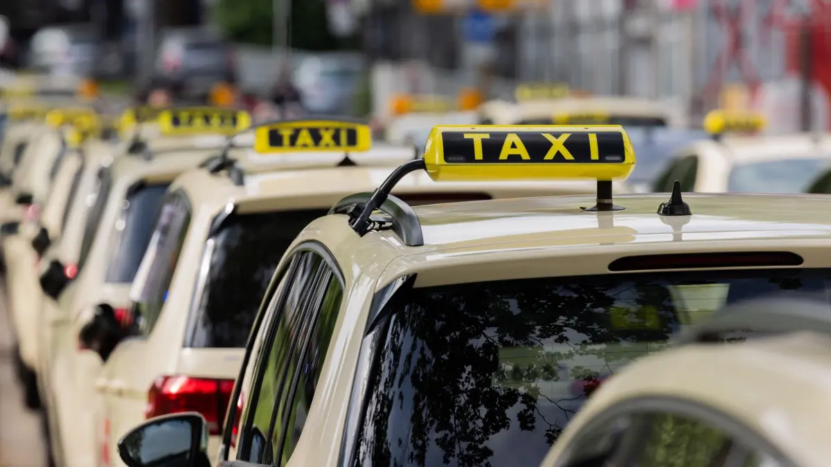 Taxifahrer: ARCHIV - 07.05.2025, Nordrhein-Westfalen, Essen: Taxifahrer blockieren aus Protest gegen Mietwagenanbieter wie Uber die Hauptverkehrsstraße Schützenbahn vor dem Rathaus. Mit strikten Preisvorgaben für Uber und andere Anbieter von Mietwagen-Fahrten will die Stadt Essen die Taxi-Branche vor einem ruinösen Wettbewerb schützen. Der Rat hat beschlossen, dass private Anbieter ihre Fahrten in Essen ab 1. Januar nicht mehr sehr viel günstiger anbieten dürfen als nach Taxi-Tarif. (zu dpa: «Vorgabe für Uber-Fahrten: Wie Essen das Taxi schützen will») Foto: Rolf Vennenbernd/dpa +++ dpa-Bildfunk +++