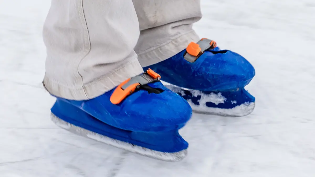Eisbahn in Burg (Spreewald): Schlittschuhe eines Mädchens gleiten über das Eis.