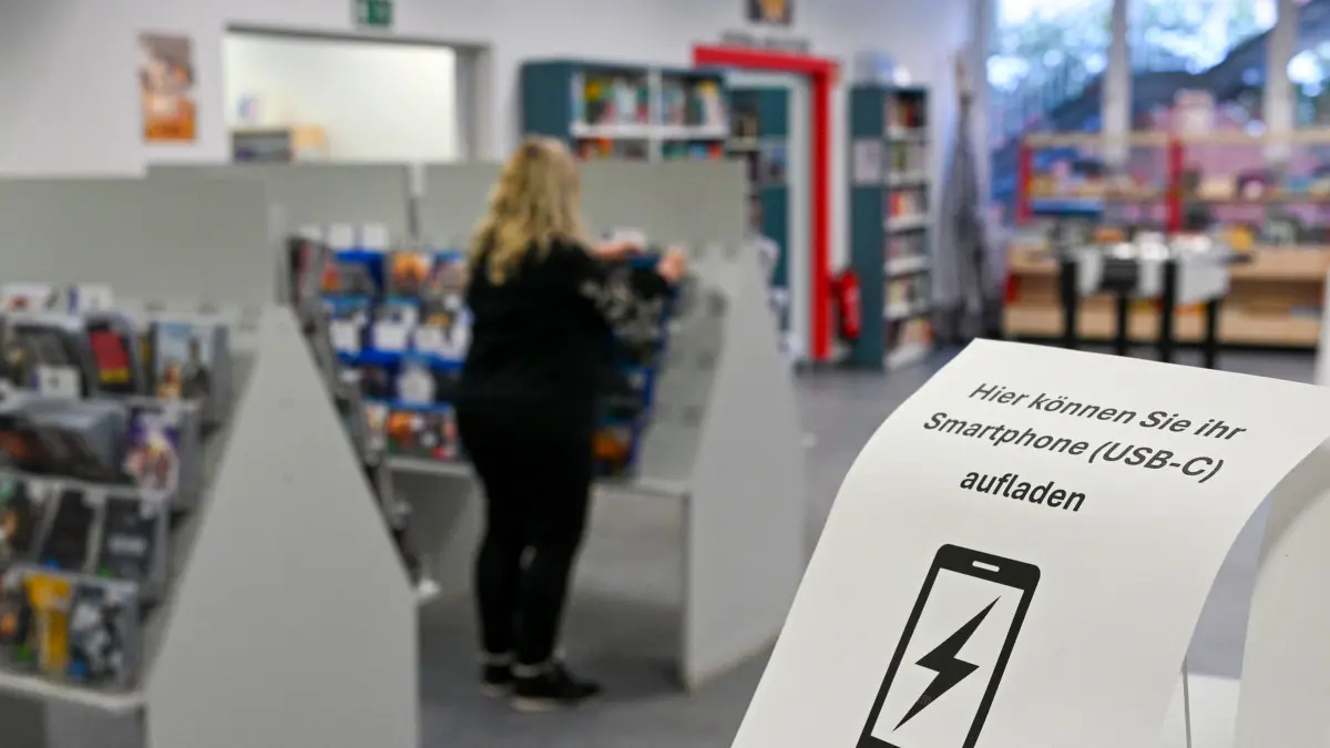 Stromausfall im Südwesten Berlins: 06.01.2026, Berlin: Die Gottfried-Benn-Bibliothek bietet Menschen im Gebiet ohne Strom die Möglichkeit, Smartphones zu laden und bietet auch Tee an. Zehntausende Menschen im Südwesten der Hauptstadt haben keinen Strom. Foto: Jens Kalaene/dpa +++ dpa-Bildfunk +++
