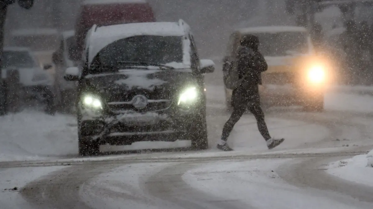 Schnee in Nordrhein-Westfalen: 07.01.2026, Nordrhein-Westfalen, Düsseldorf: Autos und Fussgänger kämpfen mit dem Schnee. In Nordrhein-Westfalen kündigt sich neuer Schnee an. Von Westen nach Osten sollen heute nach Prognose des Deutschen Wetterdienstes (DWD) Schneefälle über das Land hinweg ziehen. Dabei könne es bis zum Abend verbreitet Neuschnee mit ein bis fünf Zentimetern, in manchen Lagen auch bis zu zehn Zentimetern geben. Es bleibt kalt und frostig bei Temperaturen bis zu minus 5 Grad. Foto: Federico Gambarini/dpa +++ dpa-Bildfunk +++