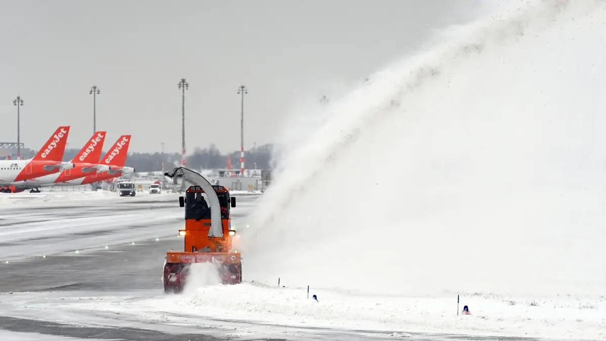 Winterwetter - Schönefeld: ARCHIV - 09.02.2021, Brandenburg, Schönefeld: Eine Schneefräse bläst auf dem Flughafen Berlin Brandenburg «Willy Brandt» den Schnee von einer Rollbahn. (zu dpa: «BER rüstet sich für Wintereinbruch – Verspätungen drohen») Foto: Soeren Stache/dpa-Zentralbild/dpa +++ dpa-Bildfunk +++