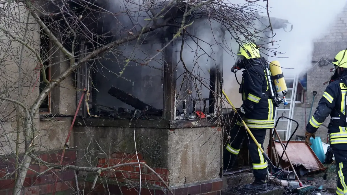 Atemschutzgeräteträger versuchen, im Zuge der Brandbekämpfung den Anbau einzureißen.