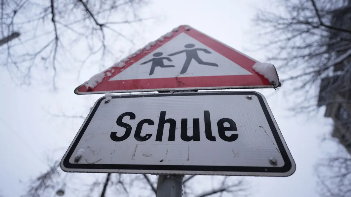 Winterwetter - Schulausfall in Hamburg: 08.01.2026, Hamburg: Schnee liegt auf einem Verkehrsschild und Hinweisschild mit der Aufschrift „Schule“ vor einer Schule im Stadtteil St. Georg. Die Schulen in Hamburg bleiben wegen der Witterungsverhältnisse und des erwarteten starken Schneefalls am Freitag geschlossen. Das teilte die Schulbehörde mit. Foto: Marcus Brandt/dpa +++ dpa-Bildfunk +++