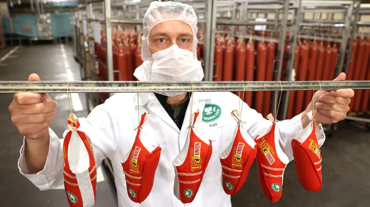 Die EWN Eberswalder Wurstspezialitäten in Britz waren auch Sponsor des 1. FC Union Berlin. Hier der stellvertretende Werksleiter Robert Klein im Mai 2025 mit Salami in Fußballschuh-Form.