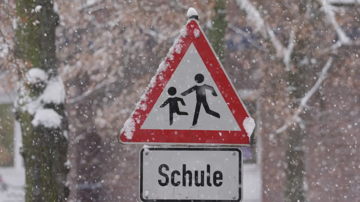 Schnee liegt auf einem Verkehrsschild und Hinweisschild mit der Aufschrift „Schule“ vor einer Schule im Stadtteil St. Georg. Die Schulen in Hamburg bleiben wegen der Witterungsverhältnisse und des erwarteten starken Schneefalls am Freitag geschlossen. Das teilte die Schulbehörde mit. +++ dpa-Bildfunk +++