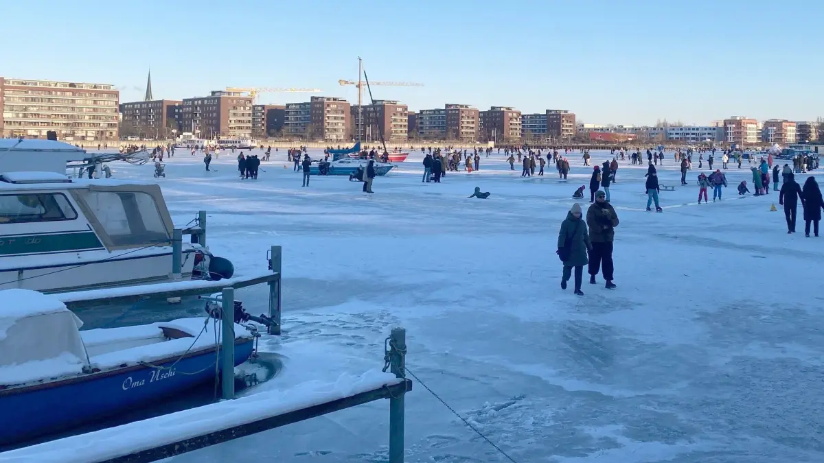 Winterwetter in Berlin: 11.01.2026, Berlin: Menschen gehen über das Eis der zugefrorenen Rummelsburger Bucht. Foto: Anja Mia Neumann/dpa +++ dpa-Bildfunk +++
