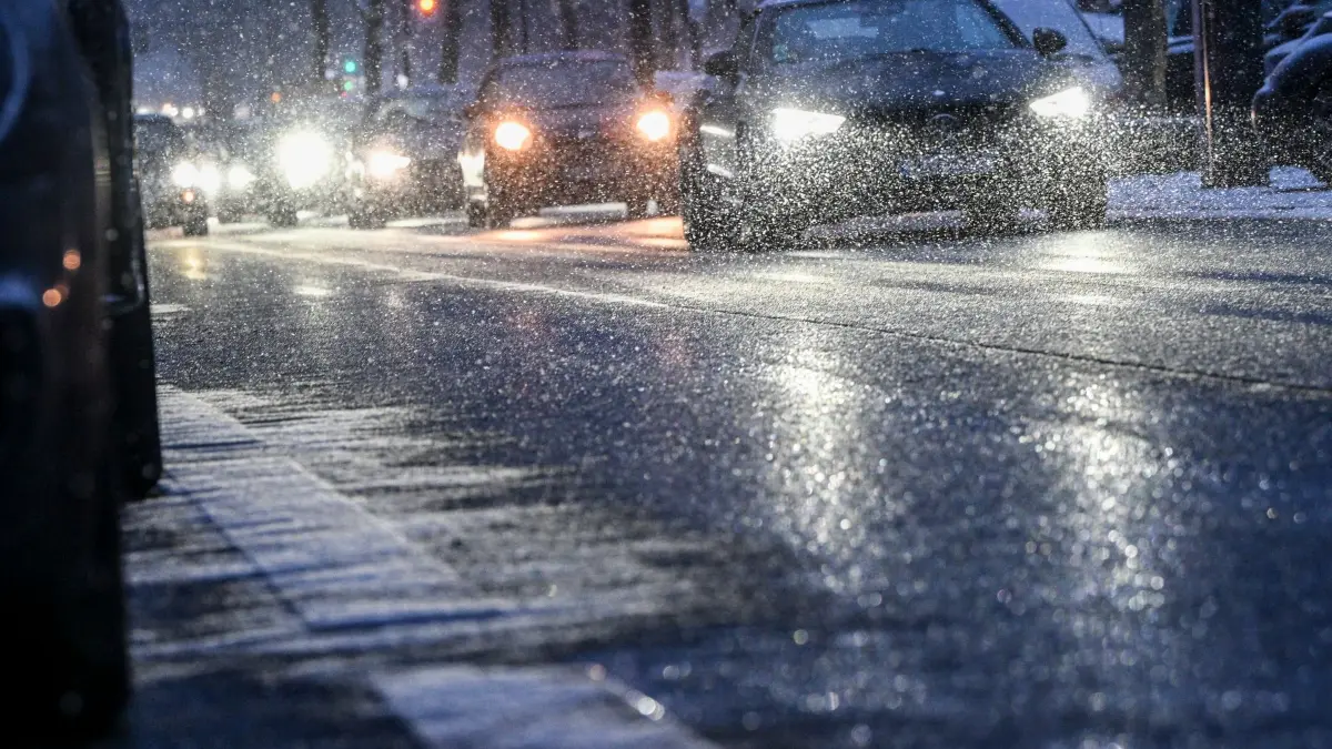 Winterwetter in Berlin: 12.01.2026, Berlin: Autos sind am frühen Abend bei einsetzendem Schneefall auf dem Kurfürstendamm unterwegs. Foto: Jens Kalaene/dpa +++ dpa-Bildfunk +++