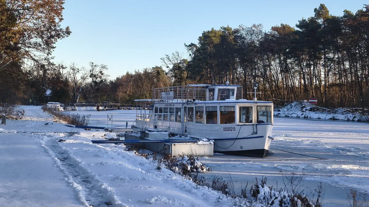 Festgefroren im Eis: die Freiherr von Münchhausen am Sonntag (11. Januar) am Anleger in Liepe. Bei genauem Hinschauen sieht man die Rinnen, die rund um das Schiff ins Eis gesägt wurden.