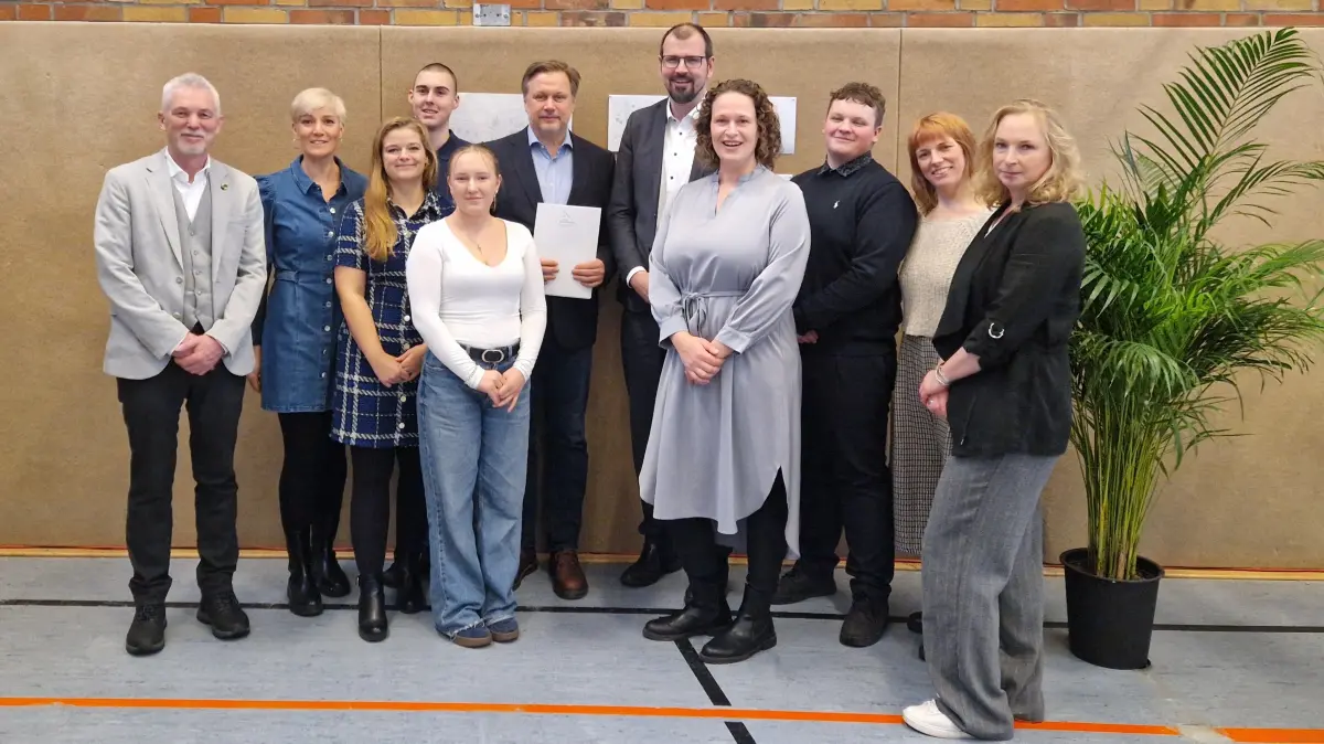 Morus-Oberschule Erkner: Für die Übergabe der Genehmigung für eine Gesamtschule kamen Bildungsminister Steffen Freiberg (hinten Mitte) mit Schülern und Schülerinnen, mit Landrat Frank Steffen, Becky Meyer-Grundwald (Leiterin Schulverwaltungsamt (r.), Schulleiterinnen Jana Demmig (vorne Mitte), Stellvertreterin Stefanie Wagner (2.v.r.) und Bürgermeister Henryk Pilz (l.) zusammen.