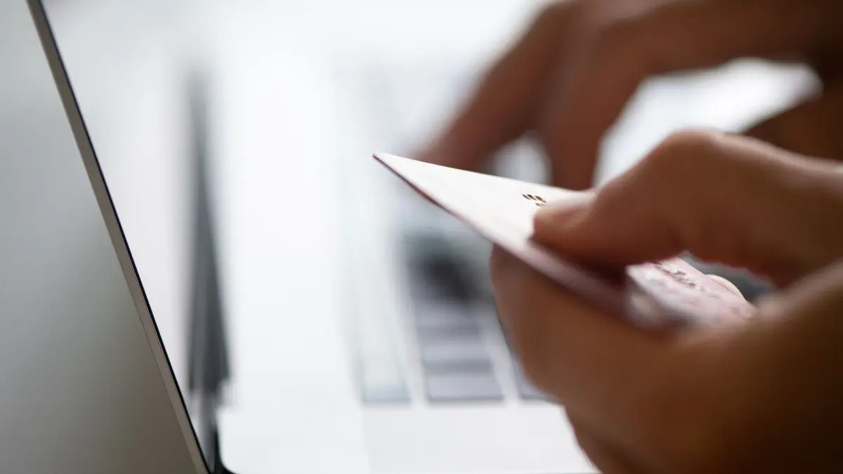 Mann sitzt mit Kreditkarte vor einem Laptop: ILLUSTRATION - Auch ein Käuferschutz: Wer mit seiner Kreditkarte, etwa Mastercard oder Visa, bezahlt hat, kann im Konfliktfall oder bei einem Zahlungsausfall des Händlers versuchen, das Geld zurückbuchen zu lassen (Chargeback-Verfahren). (zu dpa: «Auf Nummer sicher beim Einkaufen im Netz») Foto: Franziska Gabbert/dpa-tmn - Honorarfrei nur für Bezieher des dpa-Themendienstes +++ dpa-Themendienst +++