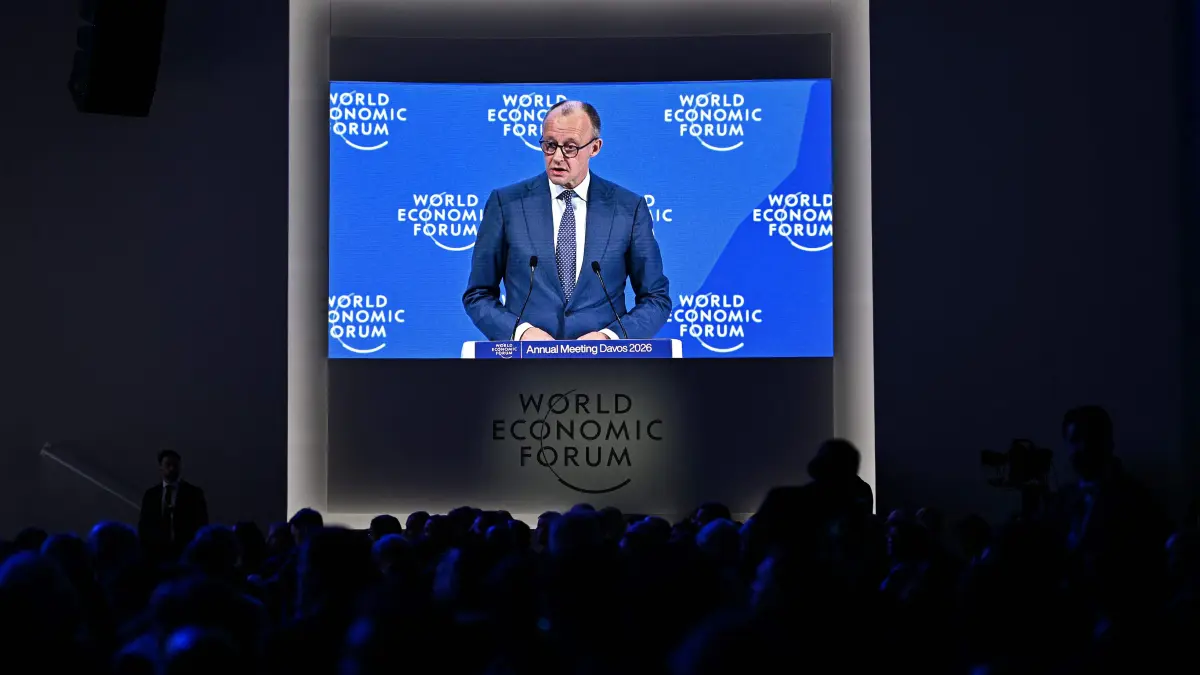 Germany's Chancellor Friedrich Merz is seen on a big screen as he delivers a special address during the World Economic Forum (WEF) annual meeting in Davos on January 22, 2026. The World Economic Forum takes place in Davos from January 19 to January 23, 2026. (Photo by Fabrice COFFRINI / AFP)