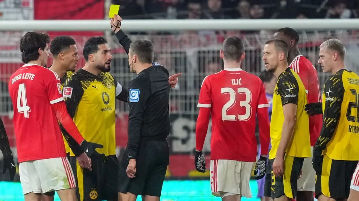 1. FC Union Berlin - Borussia Dortmund: 24.01.2026, Berlin: Fußball: Bundesliga, 1. FC Union Berlin - Borussia Dortmund, 19. Spieltag, An der Alten Försterei, Schiedsrichter Robert Hartmann (M) zeigt Emre Can (Borussia Dortmund) die gelbe Karte. (zu dpa: «Kein geladener Gast mehr? BVB-Can Zielscheibe von Union-Fans») Foto: Soeren Stache/dpa - WICHTIGER HINWEIS: Gemäß den Vorgaben der DFL Deutsche Fußball Liga bzw. des DFB Deutscher Fußball-Bund ist es untersagt, in dem Stadion und/oder vom Spiel angefertigte Fotoaufnahmen in Form von Sequenzbildern und/oder videoähnlichen Fotostrecken zu verwerten bzw. verwerten zu lassen. +++ dpa-Bildfunk +++