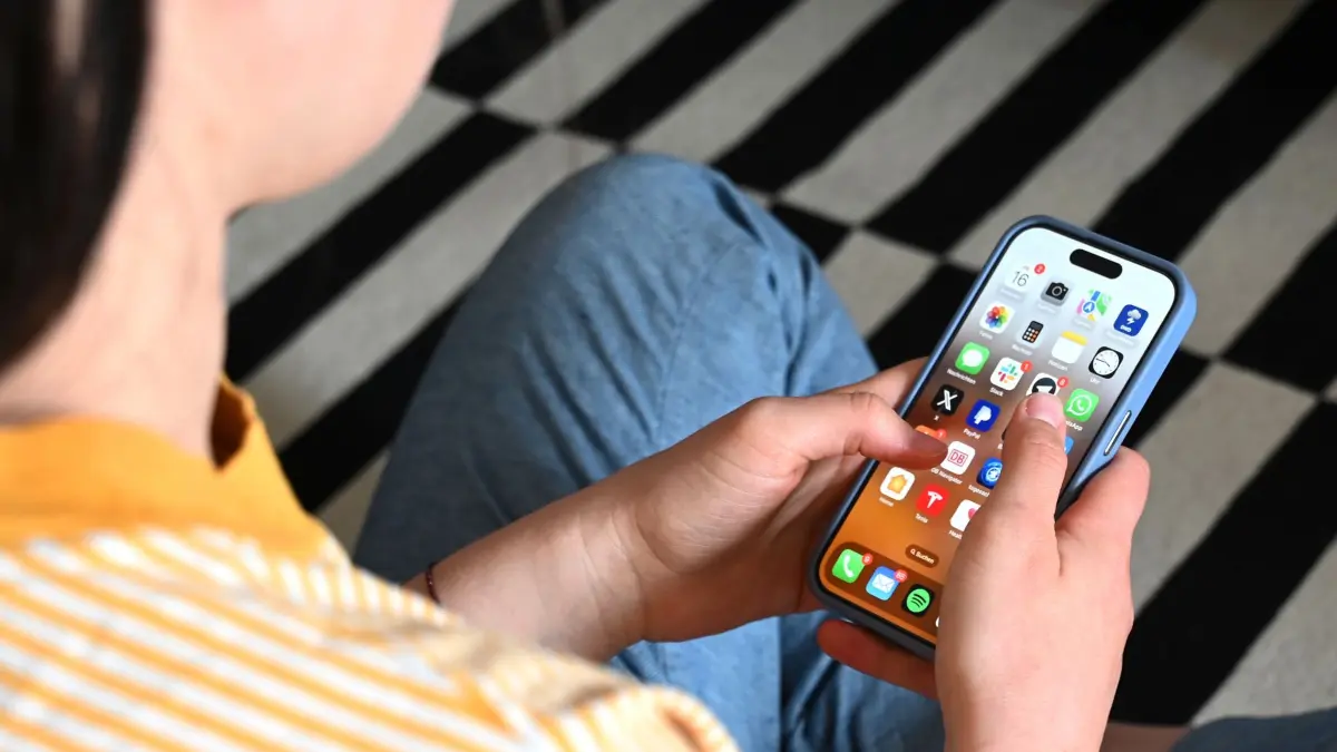 Smartphone-Nutzung bei Jugendlichen: SYMBOLBILD - 17.05.2025, Sachsen, Leipzig: Eine Jugendliche sitzt auf dem Boden und nutzt ein Smartphone - auf dem Display sind verschiedene Apps zu sehen. (zu dpa: «Social-Media-Verbot bis zum. 15 Lebensjahr in Frankreich?») Foto: Elisa Schu/dpa +++ dpa-Bildfunk +++