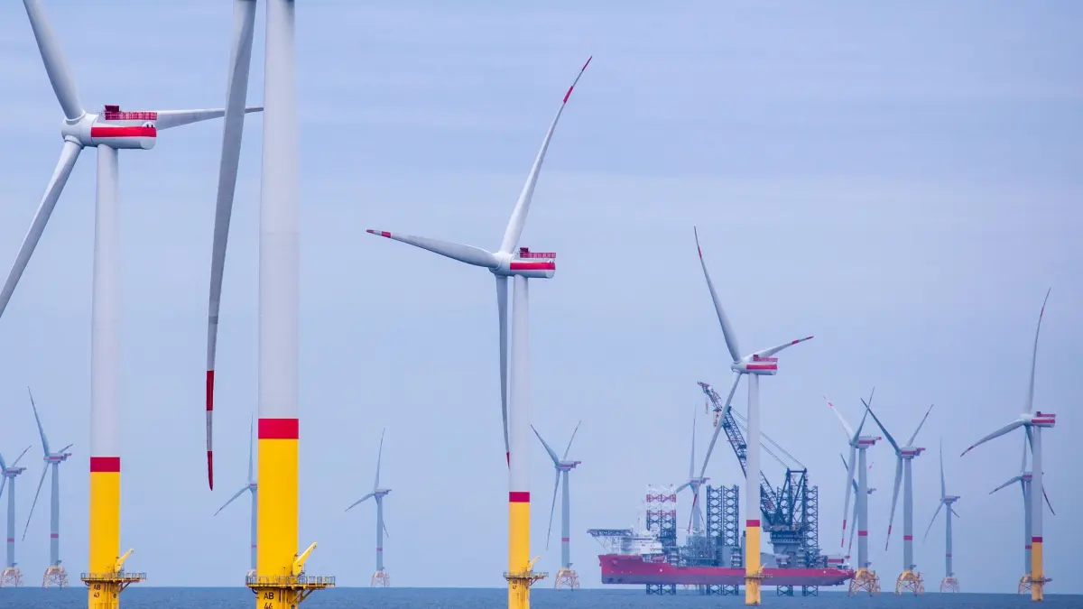 Windpark in der Ostsee.: ARCHIV - 22.08.2020, Mecklenburg-Vorpommern, Mukran: Ein Arbeitsschiff zwischen Windrädern, die in der Ostsee zwischen den Inseln Rügen und Bornholm (Dänemark) errichtet worden sind. (zu dpa: «Offshore-Windbranche rechnet mit Verfehlen des Ausbauziels») Foto: Jens Büttner/dpa-Zentralbild/dpa +++ dpa-Bildfunk +++