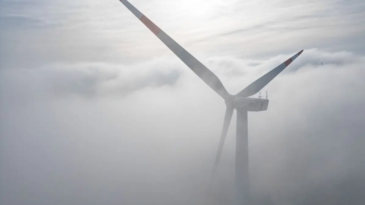 Ein Windrad im Morgennebel: ARCHIV - 18.10.2023, Sachsen-Anhalt, Querfurt: Die Windräder in einem Windpark westlich von Halle ragen aus dem Morgennebel hervor. (zu dpa: «Archäologen entdecken mittelalterlichen Gang im Harzvorland») Foto: Jan Woitas/dpa +++ dpa-Bildfunk +++