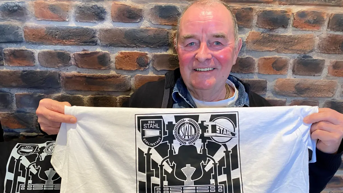 Eng verbunden mit dem Eisenhüttenstädter Stahl-Fußball: Harry Rath mit einem Trikot und den verschiedenen Emblemen der BSG Stahl und seinen Nachfolgevereinen.