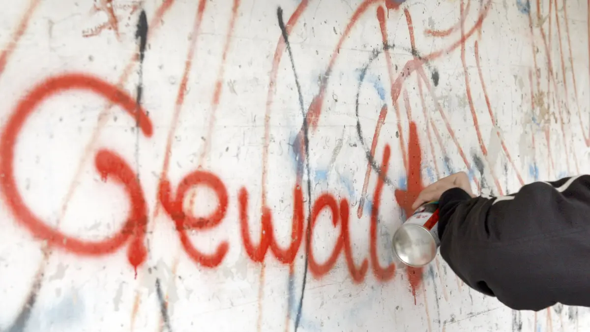 ARCHIV - Illustration zum Thema gewaltbereite Jugendliche, Gewalt bei Jugendlichen: Ein 14-jähriger Jugendlicher sprüht mit roter Farbe aus der Spraydose das Wort "Gewalt" an eine schon beschmierte Wand in Lichtenfels (Oberfranken, Archivfoto vom 10.12.2006). Nach dem brutalen Überfall auf einen Rentner in der Münchner U-Bahn hat Hessens Ministerpräsident Koch (CDU) die Diskussion über gewaltbereite Jugendliche angeheizt. «Wir haben zu viele kriminelle junge Ausländer», sagte Koch der «Bild»-Zeitung (Freitag, 28.12.2007). Foto: Marcus Führer dpa/lhe +++ dpa-Bildfunk +++