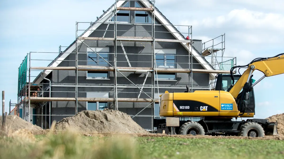 Bund gab günstige Kredite für mehr als 64.000 Wohnungen: ARCHIV - 21.03.2018, Niedersachsen, Leiferde: Ein Bagger steht vor dem Neubau eines Eigenheims. Der Bund hat im vergangenen Jahr den Bau und Kauf von mehr als 64.500 Wohnungen oder Häusern gefördert. (zu dpa: «Bund gab günstige Kredite für mehr als 64.000 Wohnungen») Foto: Hauke-Christian Dittrich/dpa/dpa-tmn +++ dpa-Bildfunk +++