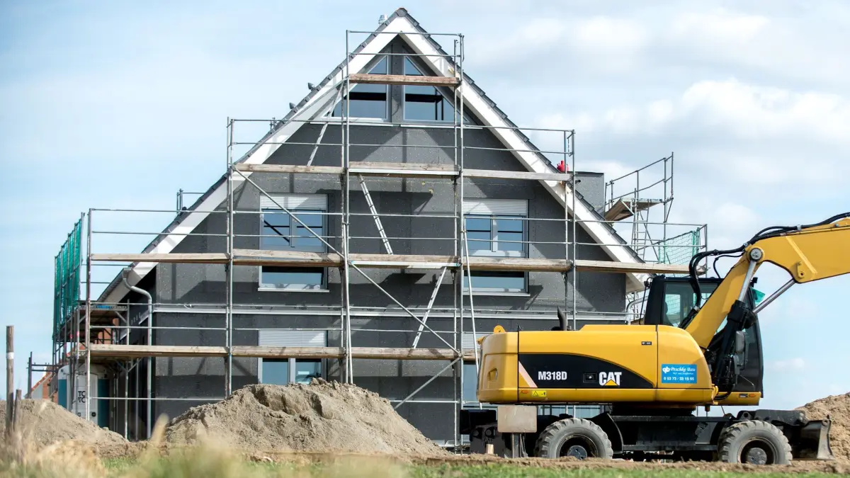 Bund gab günstige Kredite für mehr als 64.000 Wohnungen: ARCHIV - 21.03.2018, Niedersachsen, Leiferde: Ein Bagger steht vor dem Neubau eines Eigenheims. Der Bund hat im vergangenen Jahr den Bau und Kauf von mehr als 64.500 Wohnungen oder Häusern gefördert. (zu dpa: «Bund gab günstige Kredite für mehr als 64.000 Wohnungen») Foto: Hauke-Christian Dittrich/dpa/dpa-tmn +++ dpa-Bildfunk +++