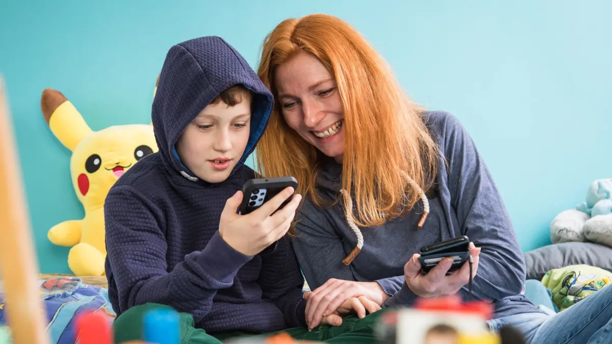 Mutter und Sohn mit Smartphones: ILLUSTRATION - Bevor der Chatbot der beste «Freund» wird: Lieber gemeinsam mit dem Thema KI auseinandersetzen. (zu dpa: «Wenn die KI zum Freund wird – worauf Eltern achten sollten») Foto: Christin Klose/dpa Themendienst/dpa-tmn - Honorarfrei nur für Bezieher des dpa-Themendienstes +++ dpa-Themendienst +++