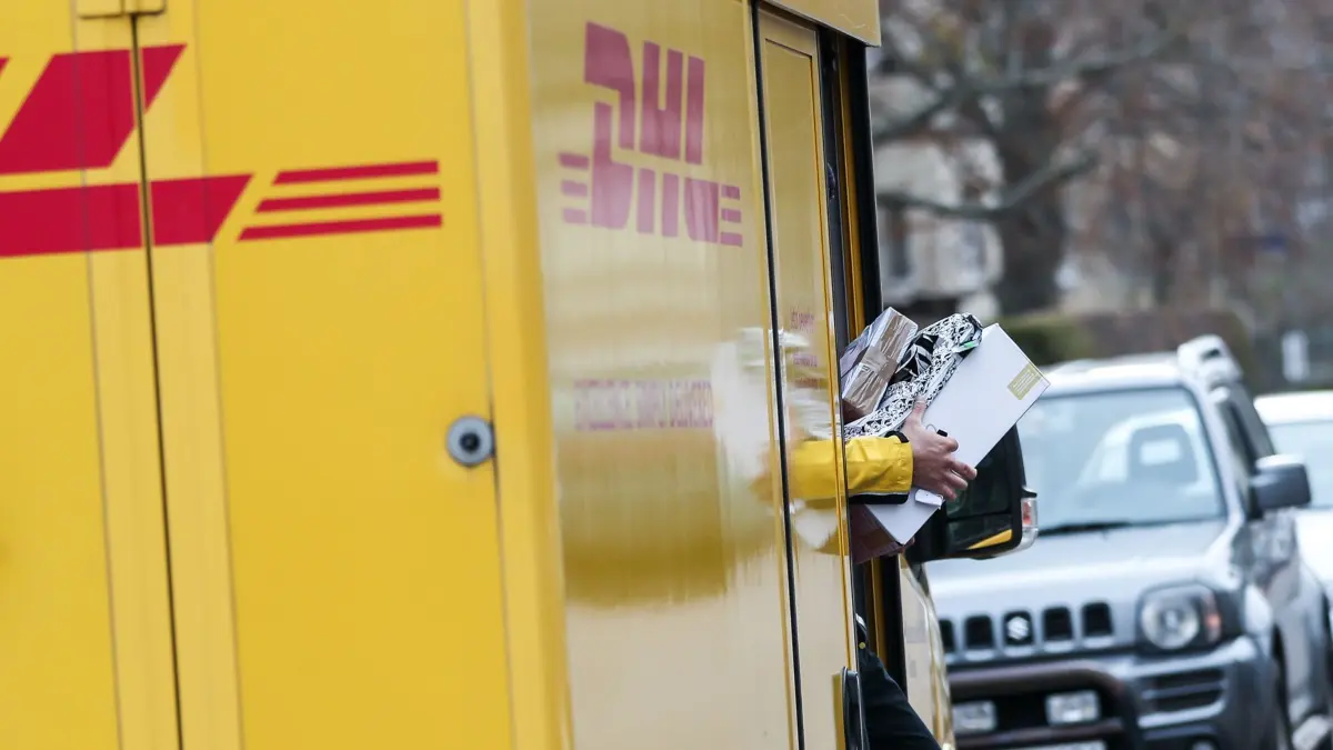 ARCHIV - 11.12.2019, Sachsen-Anhalt, Halle: Ein DHL Paketzusteller verlässt mit mehreren Sendungen sein Fahrzeug im Paulusviertel. Immer mehr Bürger machen ihrem Ärger über die Deutsche Post Luft. (zu dpa: «Post-Beschwerden erreichen Höchstwert») Foto: Jan Woitas/dpa-Zentralbild/dpa +++ dpa-Bildfunk +++