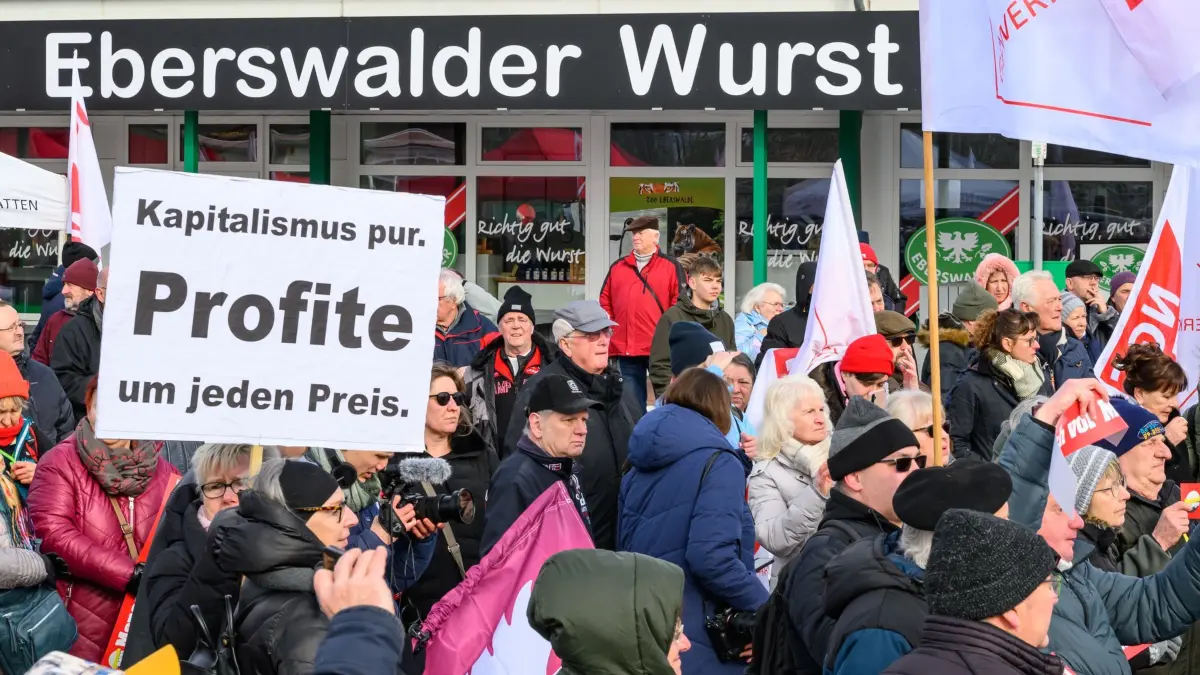 Trauerfeier für den Eberswalder Wurst-Traditionsbetrieb: 14.02.2026, Brandenburg, Britz: Viele Beschäftigte nehmen vor dem Werkstor an der «Trauerfeier» für den Eberswalder Wurst-Traditionsbetrieb teil. Aufgerufen zur Demonstration hatte die Gewerkschaft Nahrung-Genuss-Gaststätten (NGG). Das Werk wird zweieinhalb Jahren nach der Übernahme durch den Tönnies Konzern geschlossen. Für Rostbratwürste ohne Darm und Knüppelsalami ist die Marke «Eberswalder» bekannt, manchen gilt sie gar als Kultmarke aus Ostdeutschland. Doch nach fast 50 Jahren ist für die traditionsreiche Wurstfabrik im brandenburgischen Britz bei Eberswalde nordöstlich von Berlin Schluss. Ende Februar endet die Produktion. Foto: Patrick Pleul/dpa +++ dpa-Bildfunk +++