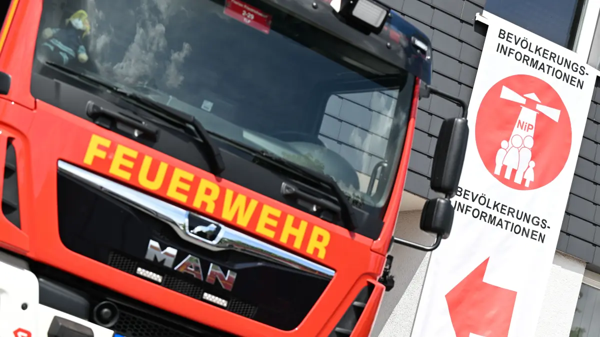 Ein Plakat mit der Aufschrift «Bevölkerungsinformationen» und einem sogenannten Katastrophenschutzleuchtturm hängt am Gebäude der Freiwilligen Feuerwehr Köppern. Die Feuerwehr ist Anlaufstelle für die Bevölkerung im Falle einer Katastrophe wie einem Blackout. Großflächige Stromausfälle, Naturkatastrophen, Pandemien, Energieengpässe oder Cyberangriffe sind mehr als nur abstrakte Szenarien. Der hessische Innenminister informiert sich auf seiner Sommertour «Krisenvorsorge und Resilienz», wie sich hessische Einrichtungen und Organisationen auf solche Gefahren vorbereiten. +++ dpa-Bildfunk +++