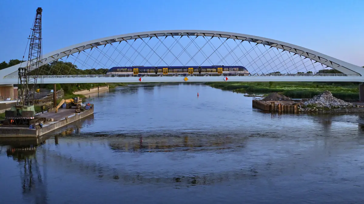 Am frühen Morgen fährt der RB26 der Niederbarnimer Eisenbahn (NEB) über die neue Bahnbrücke über den Grenzfluss Oder zwischen dem polnischen Kostrzyn und deutscher Seite Küstrin-Kietz. Offiziell fahren seit den frühen Morgenstunden, erstmalig nach Abschluss der Bauarbeiten, wieder Züge über die neue Oder-Brücke. Die Niederbarnimer Eisenbahn betreibt die RB26 im Auftrag der Länder Brandenburg und Berlin als Teil des Netzes Ostbrandenburg. Das neue 260 Meter lange Brückenbauwerk über die Oder - die weltweit erste Netzwerkbogenbrücke mit Carbonhängern - ist mit Geschwindigkeiten bis 120 Kilometer je Stunde zweigleisig befahrbar. +++ dpa-Bildfunk +++