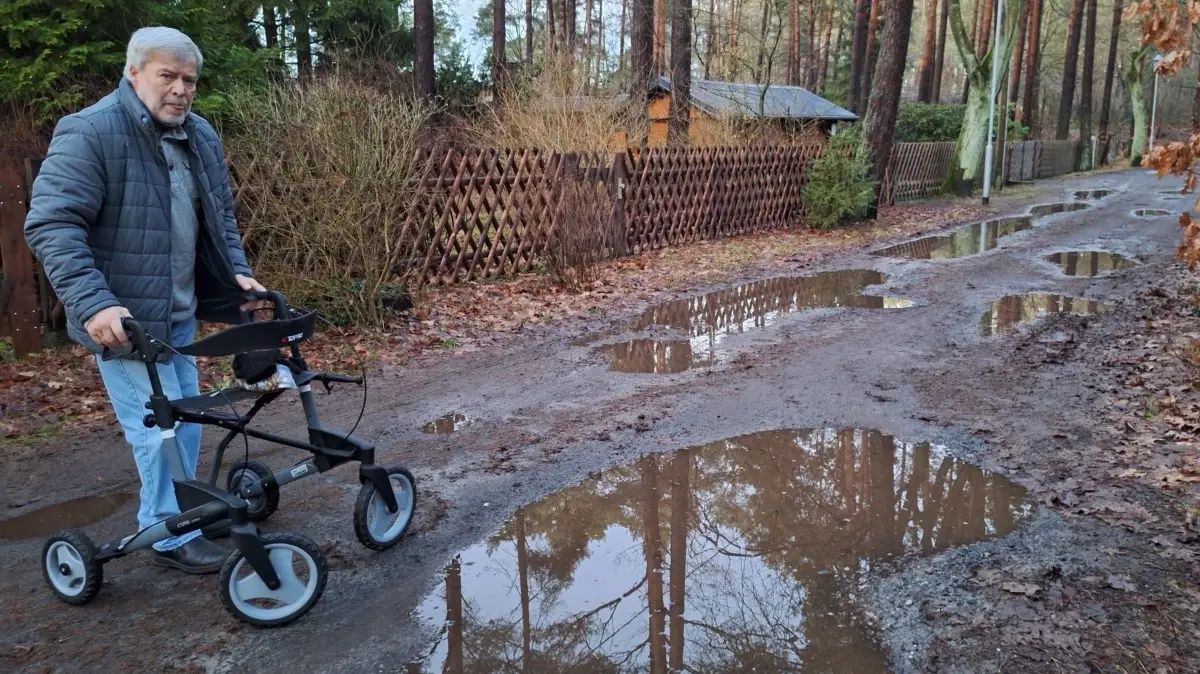 Nassenheide, Am Forstweg, Anwohner Peter Seifert, inzwischen 80 Jahre alt, kämpft seit 2020 für eine Verbesserung der Straße, die Gemeinde kann oder will aber nicht ausbessern