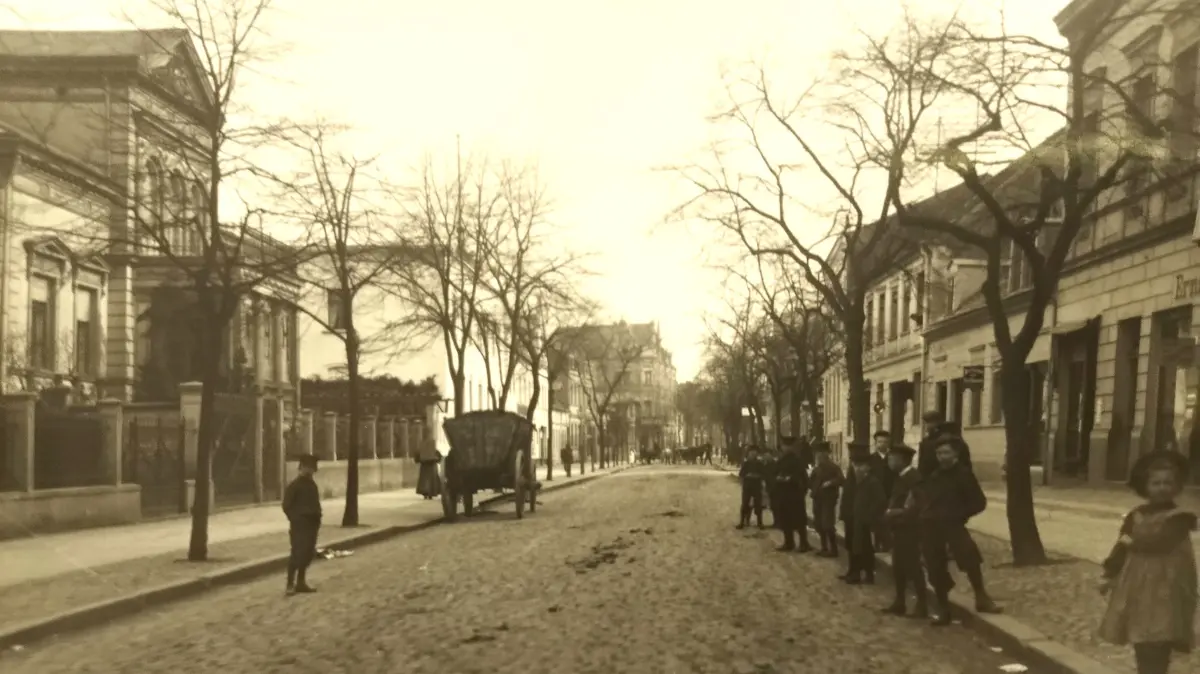 Die Eisenbahnstraße um 1910 in Blickrichtung Süden: Damals waren Pferdefuhrwerke noch an der Tagesordnung, genau wie Pferdeäpfel auf der Fahrbahn. Links ist das noch heute existierende Gebäude Eisenbahnstraße 33 zu sehen.