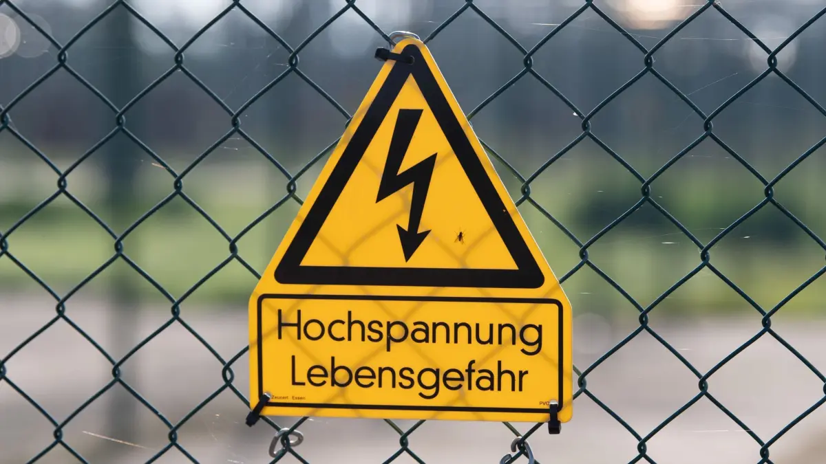 ARCHIV - 14.09.2021, Sachsen, Dresden: Ein Schild mit der Aufschrift "Hochspannung Lebensgefahr" hängt an einem Zaun vor dem Gelände des Einspeise-Umspannwerk Dresden Süd. (zu dpa: «Marder soll Stromausfall in Eltville verursacht haben») Foto: Sebastian Kahnert/dpa-Zentralbild/dpa +++ dpa-Bildfunk +++