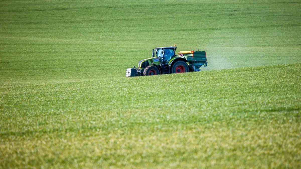 Feld wird gedüngt: ARCHIV - 08.03.2021, Mecklenburg-Vorpommern, Zierow: Ein Traktor mit einem Streuaufsatz verteilt Dünger auf einem Feld. (zu dpa: «EU macht Vorschlag für günstigere Düngemittelpreise») Foto: Jens Büttner/dpa-Zentralbild/dpa +++ dpa-Bildfunk +++