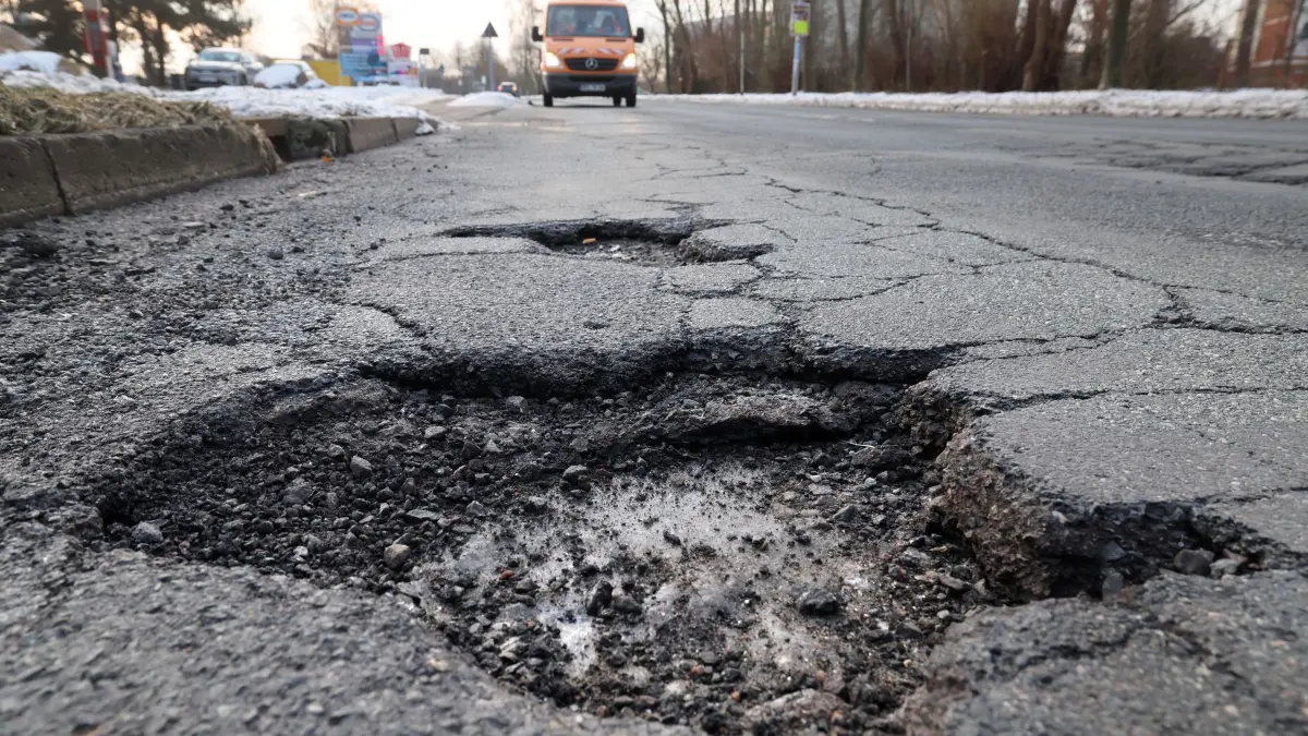 Bund und MV investieren mehr in Straßenbau: ARCHIV - 17.02.2026, Mecklenburg-Vorpommern, Rostock: Mehrere Schlaglöcher und Risse prägen die Fahrbahn nach anhaltendem Winterwetter. (zu dpa: «Bund und MV investieren mehr in Straßenbau») Foto: Bernd Wüstneck/dpa +++ dpa-Bildfunk +++