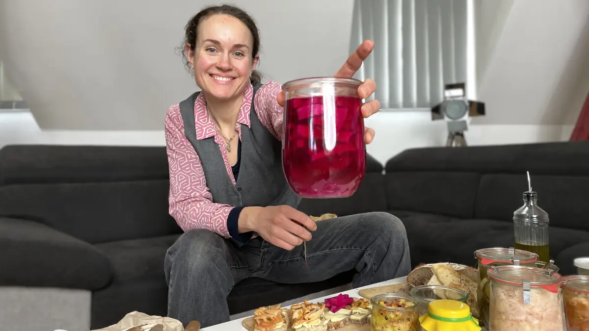 Lea Graf aus Biesenthal am 11.02.2026 im MMH-Podcaststudio in Frankfurt (Oder). Sie hält ein Glas Kohlrabi, die in Rote Bete Saft fermentiert sind, in die Kamera.