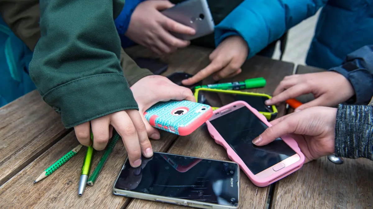 Alte Handys in der Schublade - Recycling ist die bessere Wahl: Schueler mit ihren Smartphones (Foto vom 21.02.2017). Millionen ausrangierte Mobiltelefone liegen ungenutzt in deutschen Haushalten, oft über Jahre hinweg. Statt sie aufzubewahren, sollten Mobiltelefone recycelt oder weitergegeben werden. (Siehe epd-Bericht und Video vom 03.03.2026) *** Local Caption *** 00370228