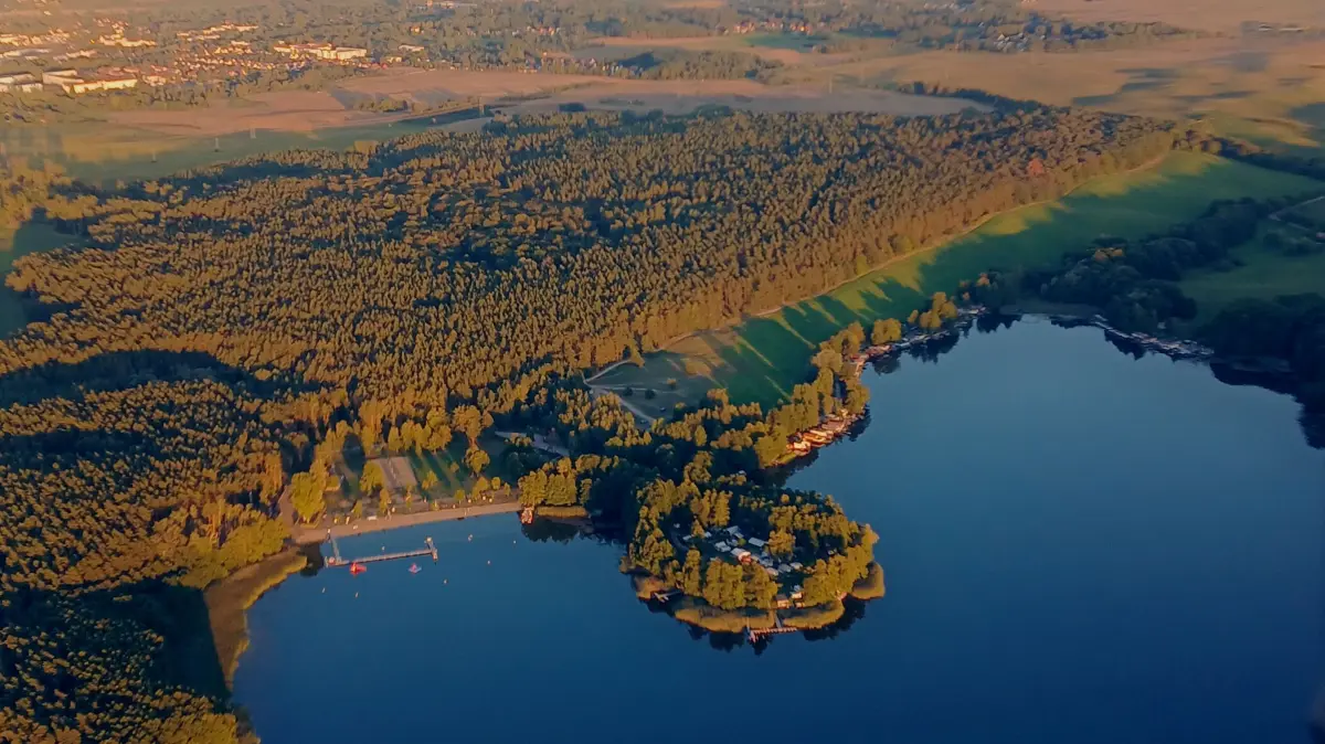 Blick auf den Wolletzsee in Angermünde mit Strandbad und der Halbinsel des Campingplatzes: Angermünde ist nah am Wasser gebaut und bietet naturnahen Tourismus. Zum Saisonstart 2026 erhebt der staatlich anerkannte Erholungsort eine Kurtaxe.