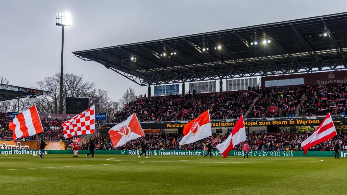 Fußball: Dritte Liga, FC Energie Cottbus - VfB Stuttgart II, LEAG Energie Stadion: Fahnenträger laufen auf das Spielfeld. Der Verein feiert heute sein 60-jähriges Bestehen.