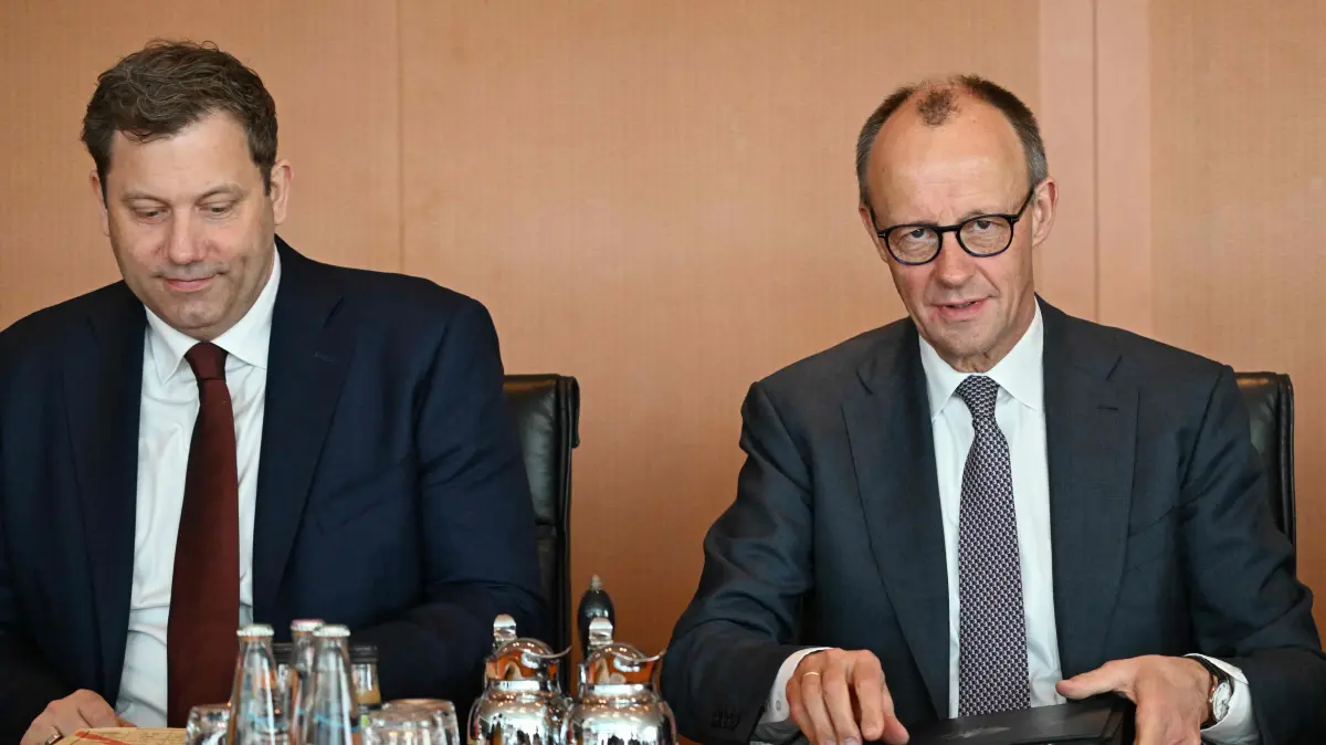 : German Chancellor Friedrich Merz (R) and German Finance Minister and Vice-Chancellor Lars Klingbeil take their seats prior to the weekly cabinet meeting, on March 11, 2026 at the Chancellery in Berlin. (Photo by RALF HIRSCHBERGER / AFP)