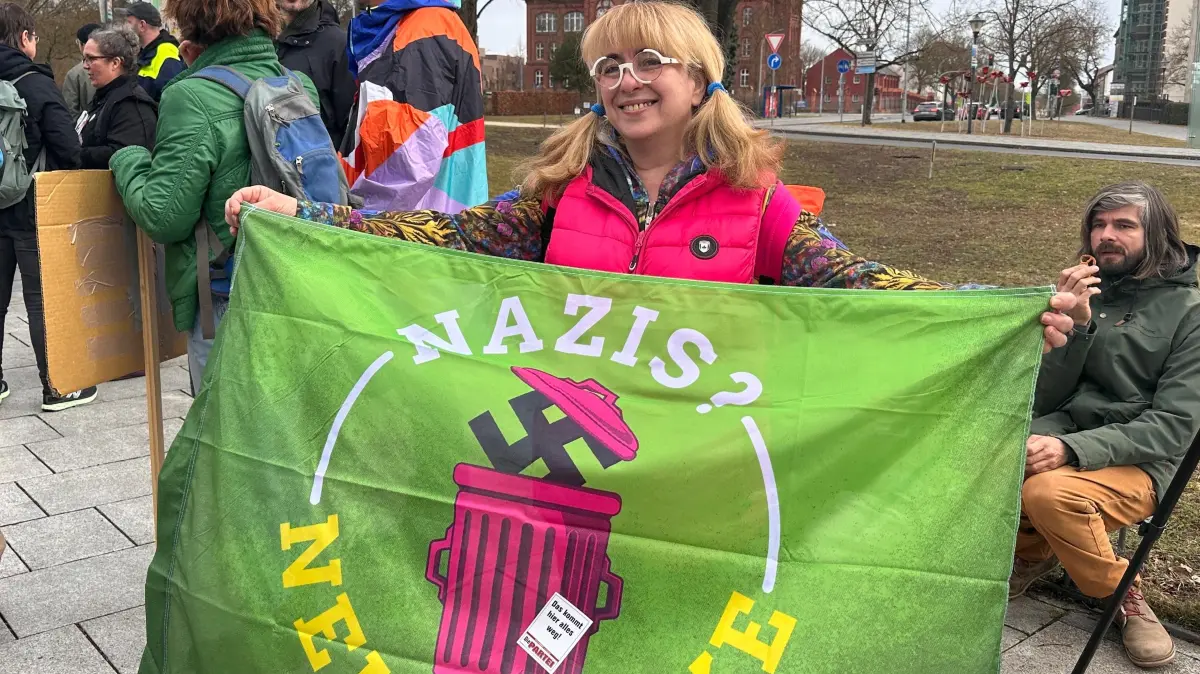 Bunter Protest gegen den AfD-Landesparteitag in Prenzlau. Eine Demonstrantin präsentiert ein Banner am 14.3.2026.