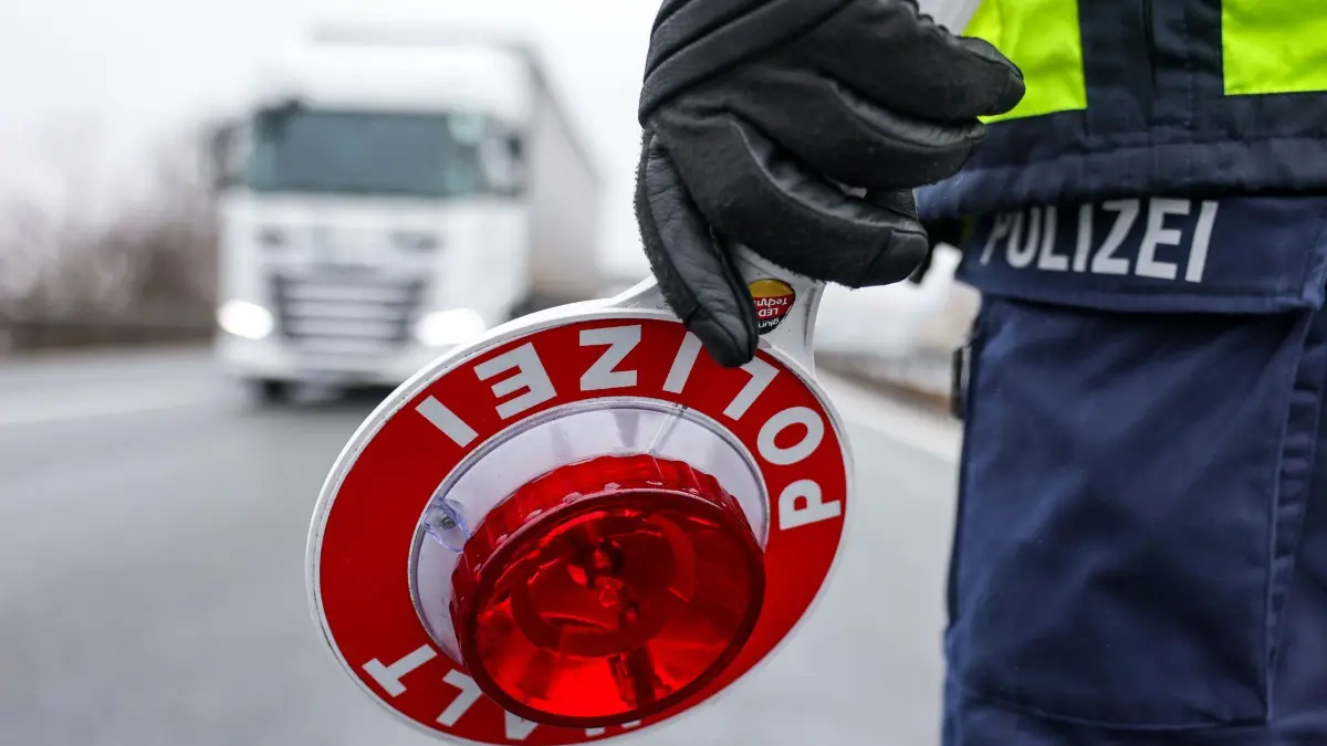 Polizeikontrolle - Illustration: ARCHIV - 05.02.2025, Sachsen, Burgstein: Ein Polizist hält eine Polizeikelle für eine Kontrolle an der Autobahn 72. (zu dpa: «Falsche Polizisten bestehlen Lkw-Fahrer auf A2») Foto: Jan Woitas/dpa +++ dpa-Bildfunk +++