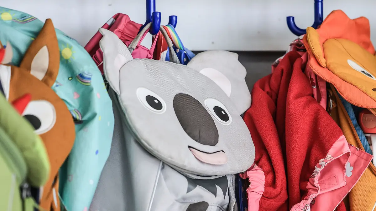 Garderobe und Taschen von Kindern hängen im Flur einer Kindertagesstätte. Alltagshelferin Philipp hilft in der Kita der Diakonie an der Duisburger Straße in Düsseldorf. (Zu dpa/lnw: „Alltagshelfer in Kitas: «Erfahren oft erst am ersten Arbeitstag, ob der Vertrag verlängert wurde»“) +++ dpa-Bildfunk +++