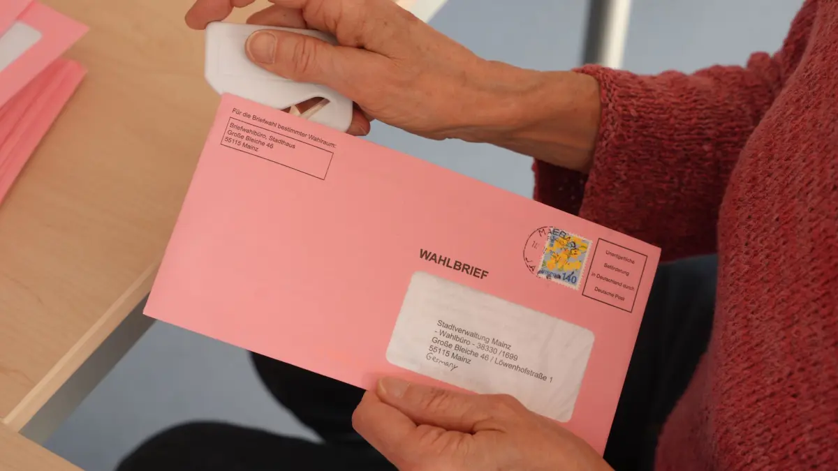 Landtagswahl in Rheinland-Pfalz: 22.03.2026, Rheinland-Pfalz, Mainz: Eine Wahlhelferin hält in einem Briefwahlbüro einen Wahlbrief in den Händen. Die ausgefüllten Unterlagen werden gesammelt und nach Schließung der Wahllokale um 18.00 Uhr ausgezählt. In Rheinland-Pfalz findet am Sonntag die Landtagswahl statt. Foto: Thomas Frey/dpa +++ dpa-Bildfunk +++