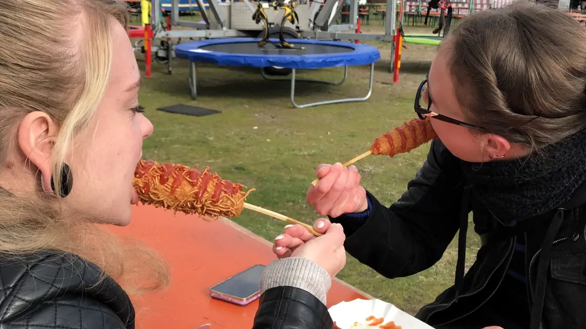 Eisenhüttenstadt. Street Food Festival auf dem Inselvorplatz. Vivi und Steffi essen koreanische Corn Dogs. 27.03.2026 Foto: Frank Groneberg