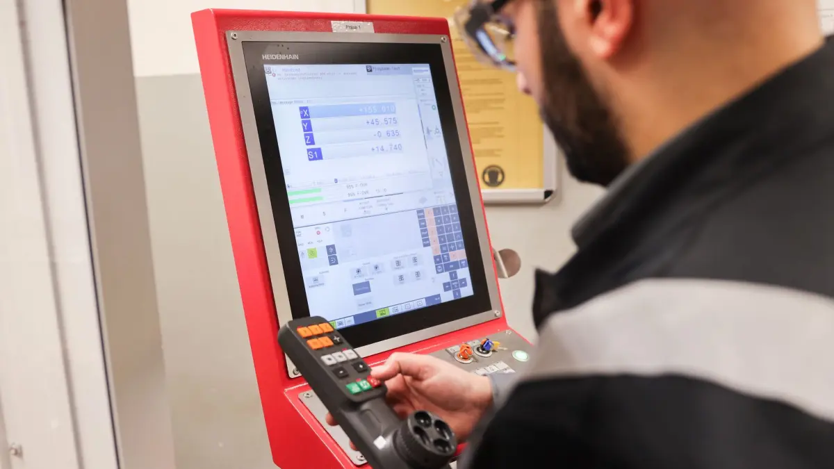 Syrer sind zum Faktor am Arbeitsmarkt geworden: ARCHIV - 12.04.2024, Schleswig-Holstein, Flensburg: Mohamad Hakam Almashhrawi aus Syrien, Auszubildender bei den Stadtwerken Flensburg, arbeitet in der Ausbildungswerkstatt an einer CNC Fräse. Insgesamt sind nach Angaben der Bundesagentur für Arbeit derzeit 320.000 Syrerinnen und Syrer sozialversicherungspflichtig in Deutschland beschäftigt – sie leisten mit ihrer Arbeit also auch Beiträge etwa für die Renten- oder Arbeitslosenversicherung. (zu dpa: «Syrer sind zum Faktor am Arbeitsmarkt geworden») Foto: Christian Charisius/dpa +++ dpa-Bildfunk +++