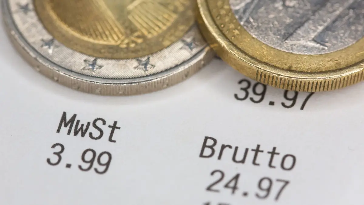 Sollte die Mehrwertsteuer auf Lebensmittel abgeschafft werden?: ILLUSTRATION - 26.11.2025, Berlin: Euro-Münzen liegen auf einem Kassenbon, auf dem unter anderem die Mehrwertsteuer und der Bruttobetrag ausgewiesen sind. (zu dpa: «Mehrwertsteuer auf Lebensmittel streichen? Zuspruch aus der Union») Foto: Fernando Gutierrez-Juarez/dpa +++ dpa-Bildfunk +++