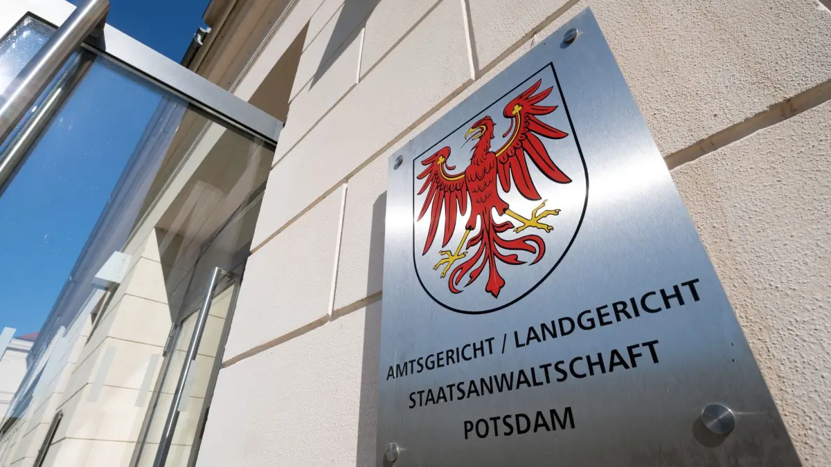 Landgericht Potsdam: ARCHIV - 25.03.2020, Brandenburg, Potsdam: Das Metallschild neben dem Eingang zum Justizzentrum mit dem roten Adler als Landeswappen und dem Verweis auf Amtsgericht, Landgericht und Staatsanwaltschaft. Nach einer tödlichen Messerattacke auf seine Ex-Ehefrau in Rathenow hat das Landgericht Potsdam einen Mann wegen Totschlags zu neuneinhalb Jahren Haft verurteilt. (zu dpa: «Prozess um Totschlag an Ex-Frau: Neuneinhalb Jahre Haft») Foto: Soeren Stache/dpa-Zentralbild/dpa +++ dpa-Bildfunk +++