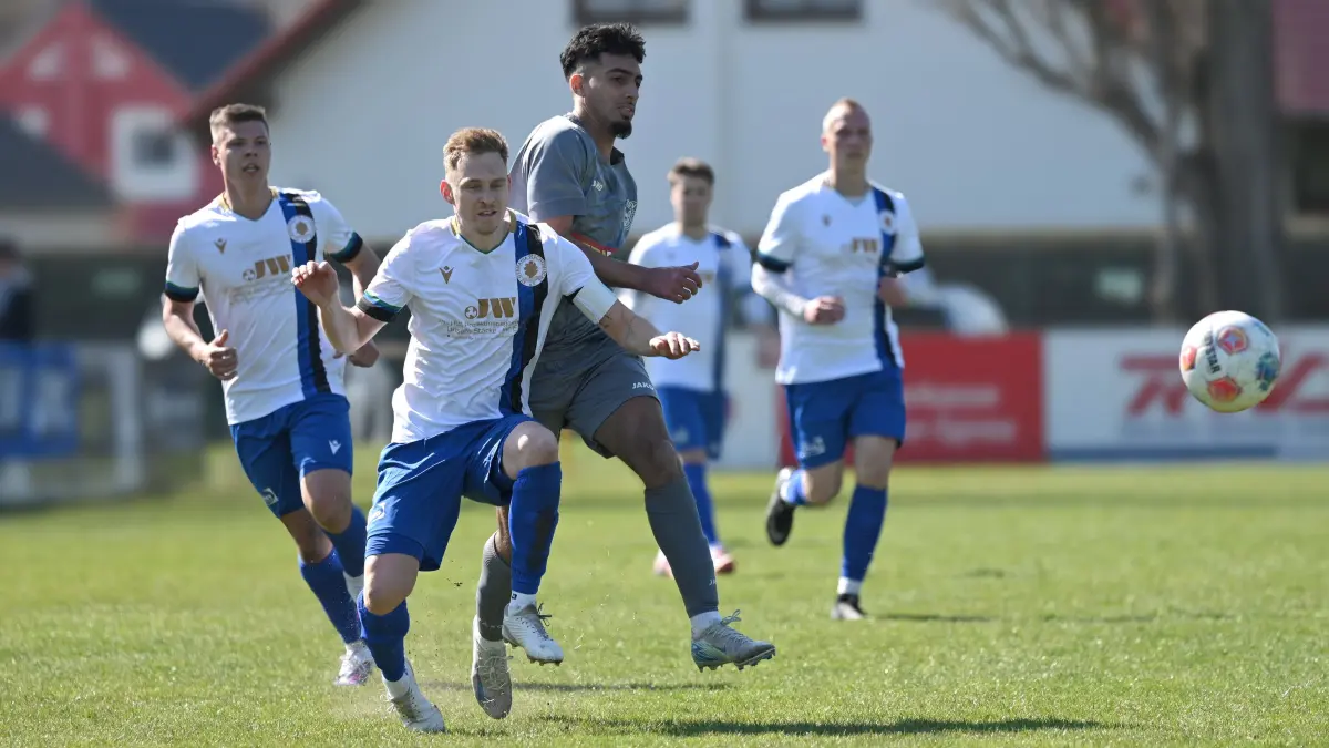 Fussball : Schöneiche, Fussball Brandenburgliga, Germania Schöneiche - MSV Neuruppin, Achraf El Mhamdi cor SF Pierre Vogt, dahinter Deniz Citlak l. und Lukas Bache
FOTO BENK 11.04.2026