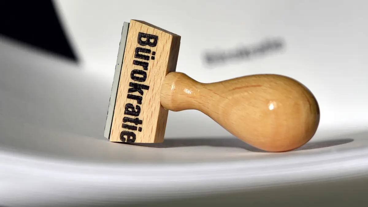 Bürokratie: ARCHIV - 12.02.2015, Brandenburg, Potsdam: Ein Stempel mit der Aufschrift «Bürokratie» liegt auf Papieren. (zu dpa: «Mehrheit sieht beim Bürokratieabbau null Fortschritt») Foto: Ralf Hirschberger/dpa-Zentralbild/dpa +++ dpa-Bildfunk +++